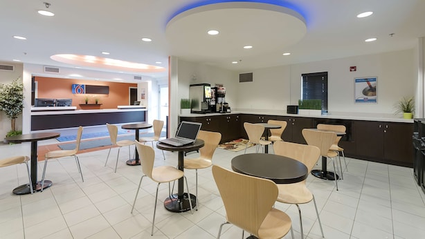 A modern restaurant with a counter, seating area, and a coffee machine. - Motel 6 Brandon, MB (Brandon)