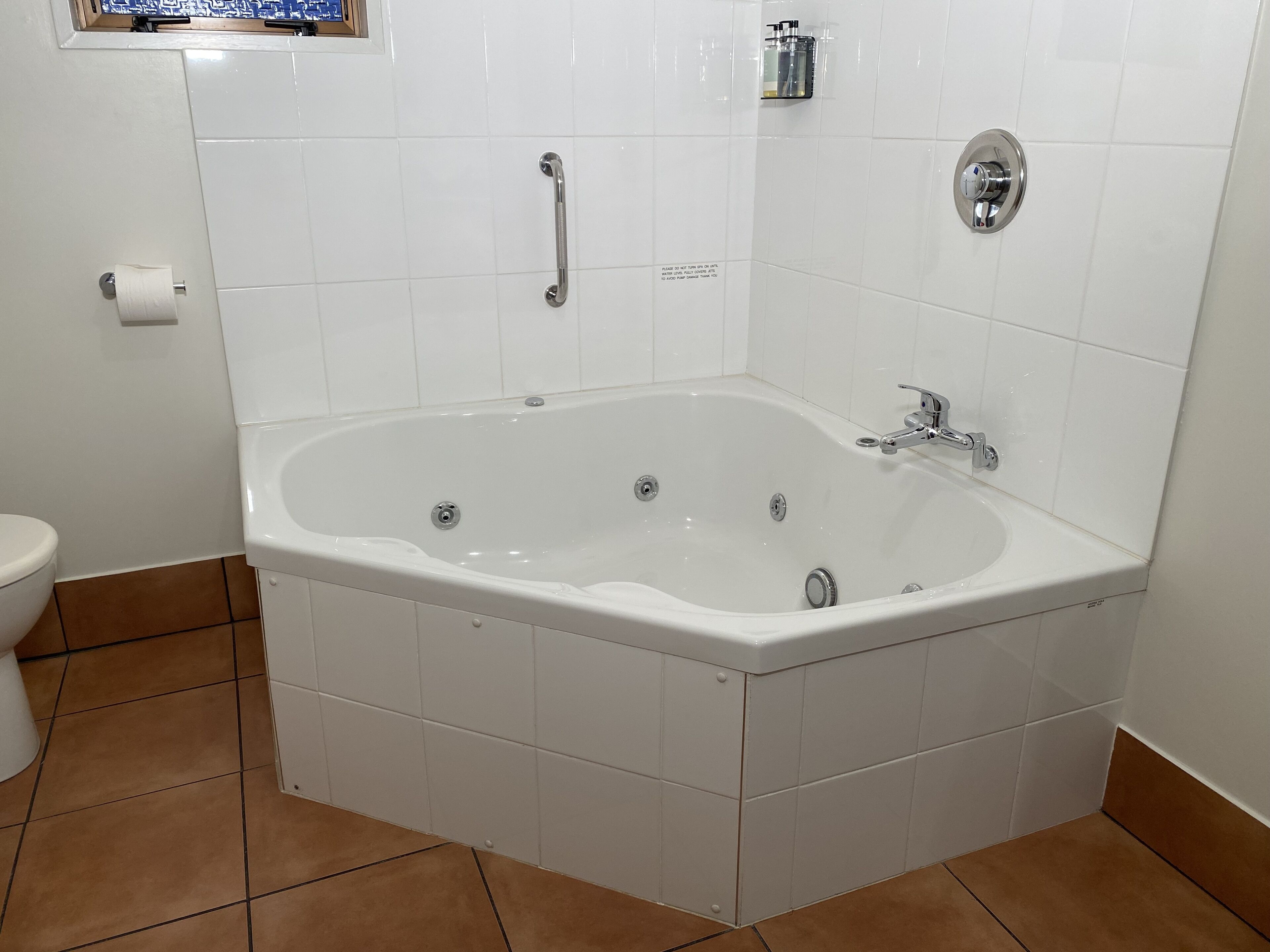 Kylpyhuone, jossa on valkoinen kylpyamme, wc ja suihkutila.