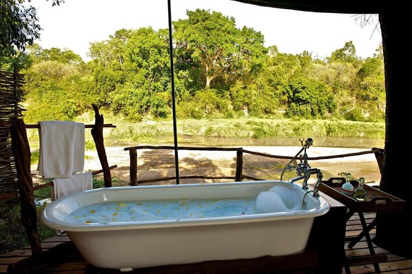 A bathtub with a view of a river and trees. - Mara Explorer (Maasai Mara)
