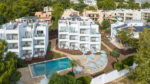 A modern hotel with multiple floors, outdoor pool, and sun loungers.
