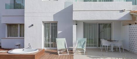 A modern building with a pool, outdoor seating, and a glass balustrade.