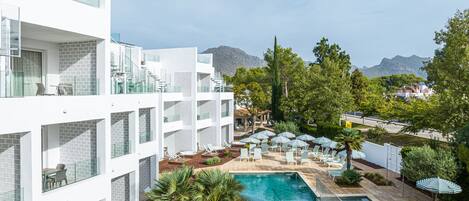 Un hôtel moderne doté d’une piscine, d’un espace extérieur aménagé et offrant une vue sur les montagnes.