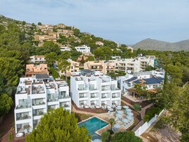 Un complejo turístico con varias construcciones, una piscina y paneles solares.