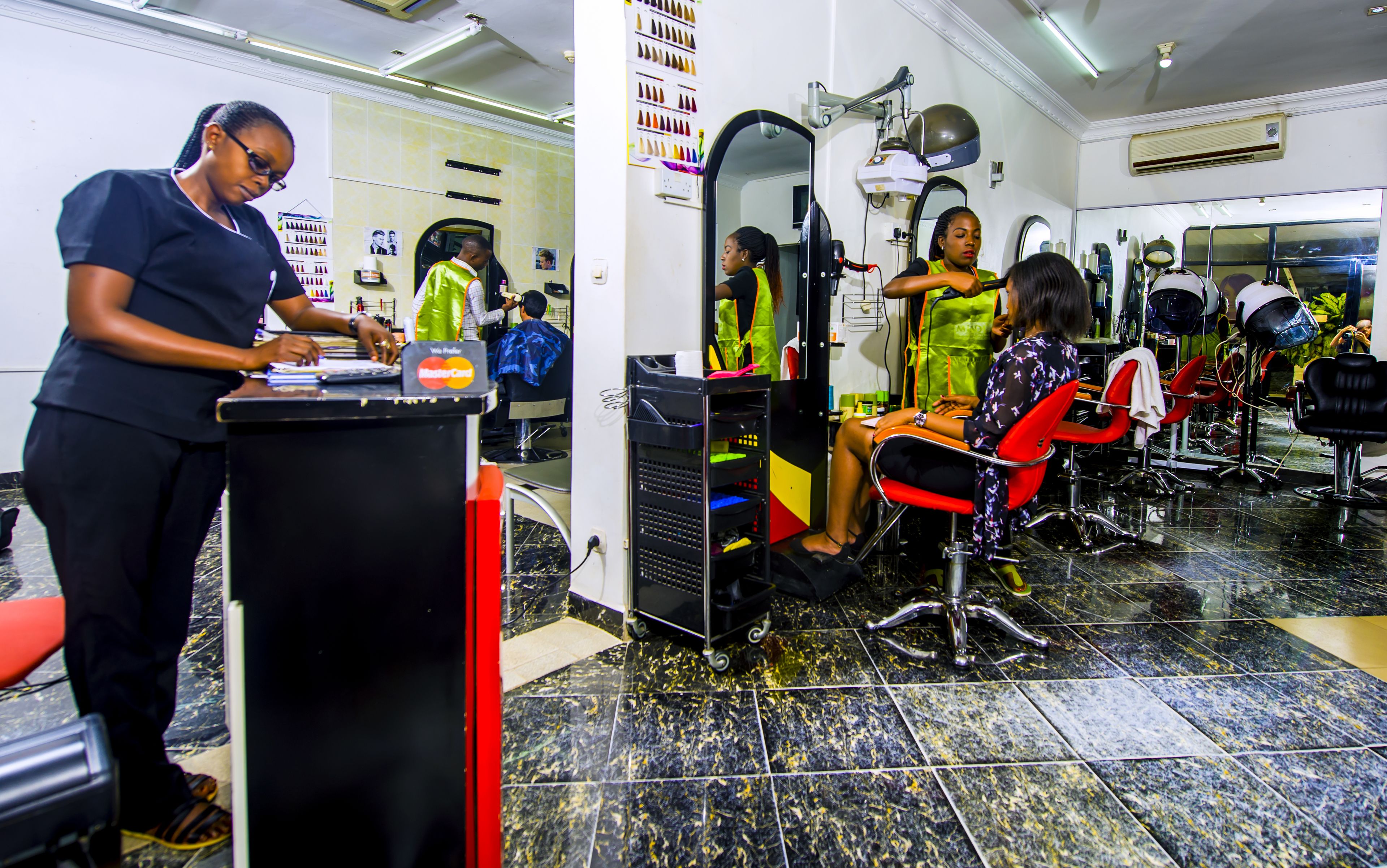 A salon with a reception desk, chairs, and various hairdressing tools.