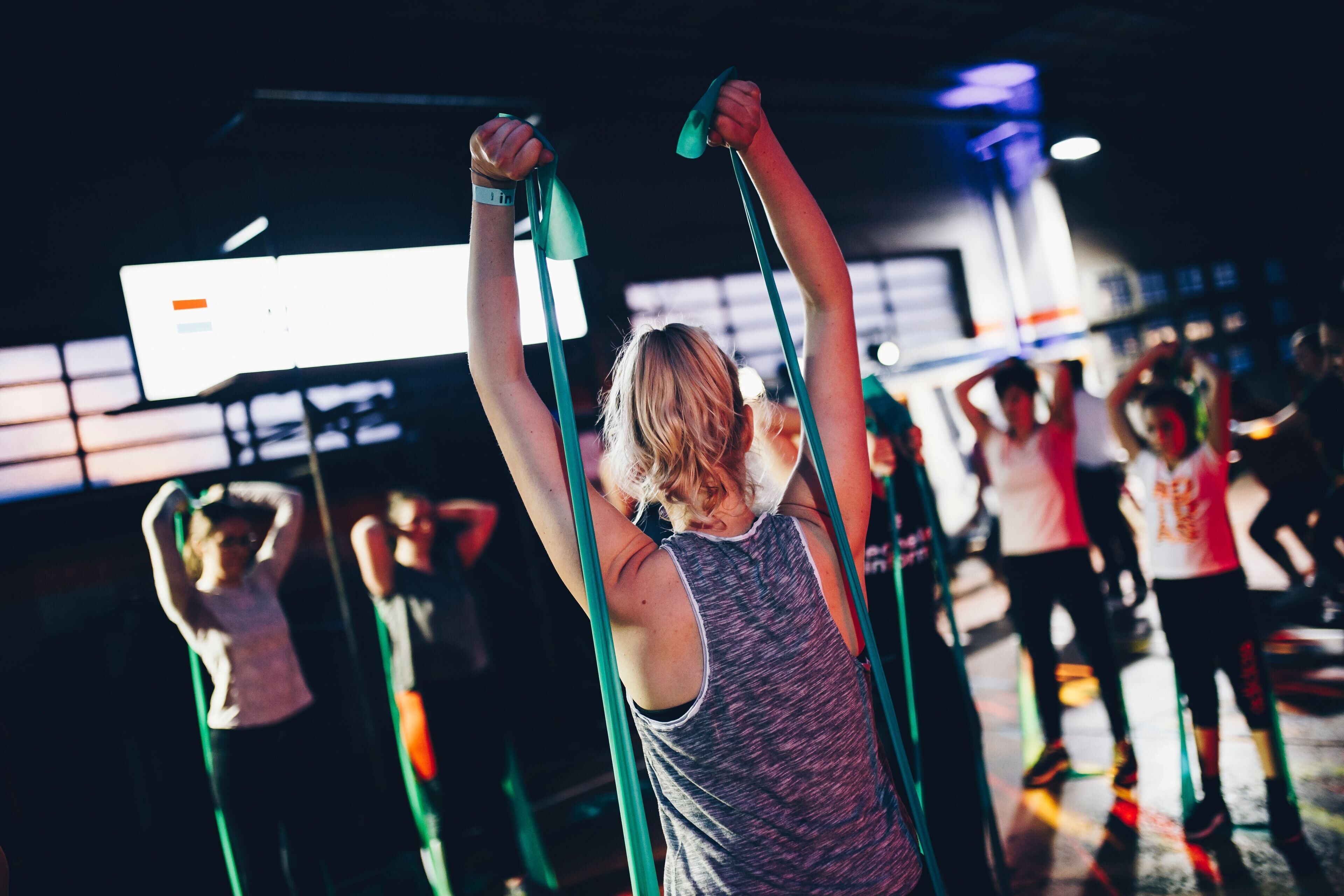 A group of people exercising with resistance bands in a gym.