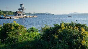 A pier with a lifeguard tower, boats, and a clear view of the water.