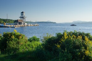A pier with a lifeguard tower, boats, and a clear view of the water.