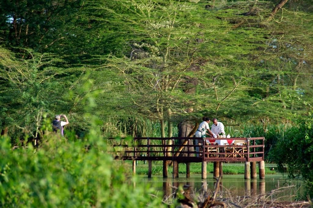 A wooden bridge over water with people on it.