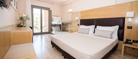 Habitación de hotel moderna con una cama grande, un escritorio y vistas al exterior.