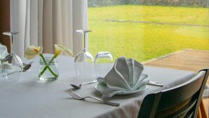 A table set for dining with a view of a coastal landscape. - Inatel Flores Hotel (Santa Cruz das Flores)