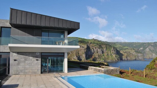A modern two-story house with a swimming pool, large windows, and a view of the sea and hills. - Inatel Flores Hotel (Santa Cruz das Flores)