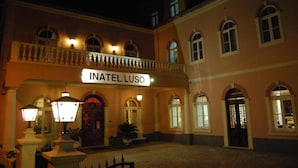 A building with a sign reading "INATEL LUSO" at the entrance, featuring a classic architectural style with arched windows and a balcony. - INATEL Luso (Mealhada)
