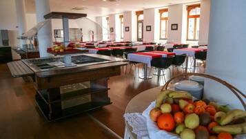 Un'area buffet con un angolo self-service e un cesto di frutta.