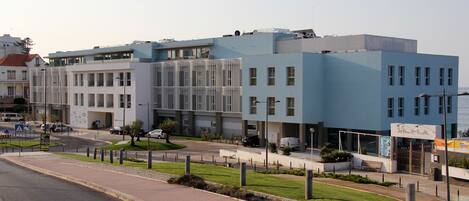 Un bâtiment moderne doté d’un toit plat, de grandes fenêtres et d’une enseigne indiquant la présence d’un restaurant.