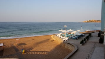 A beachside restaurant with outdoor seating and a view of the sea.