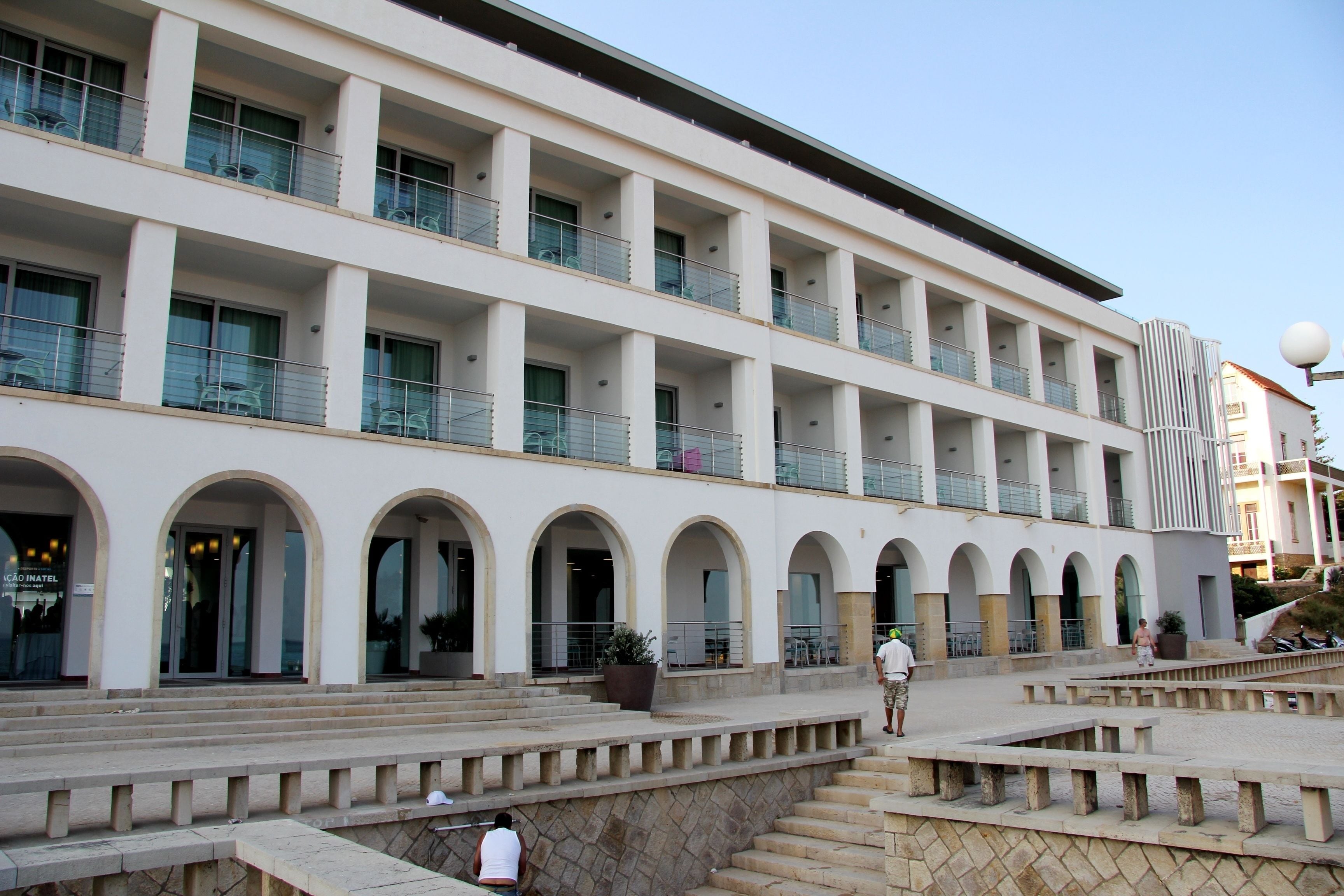 A multi-story hotel with arched balconies and a central courtyard.