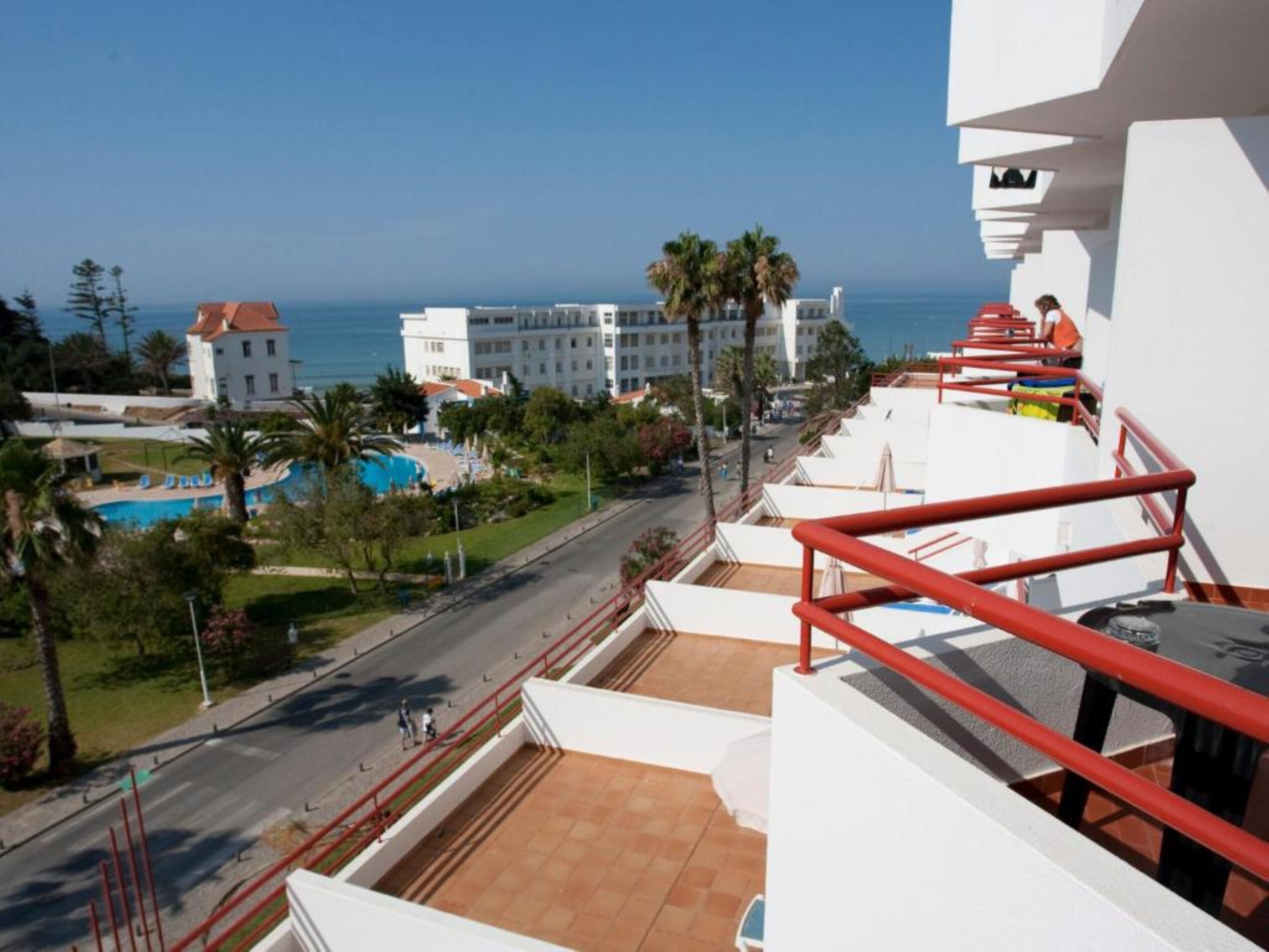 Un balcon d’hôtel avec vue sur la piscine et l’océan.