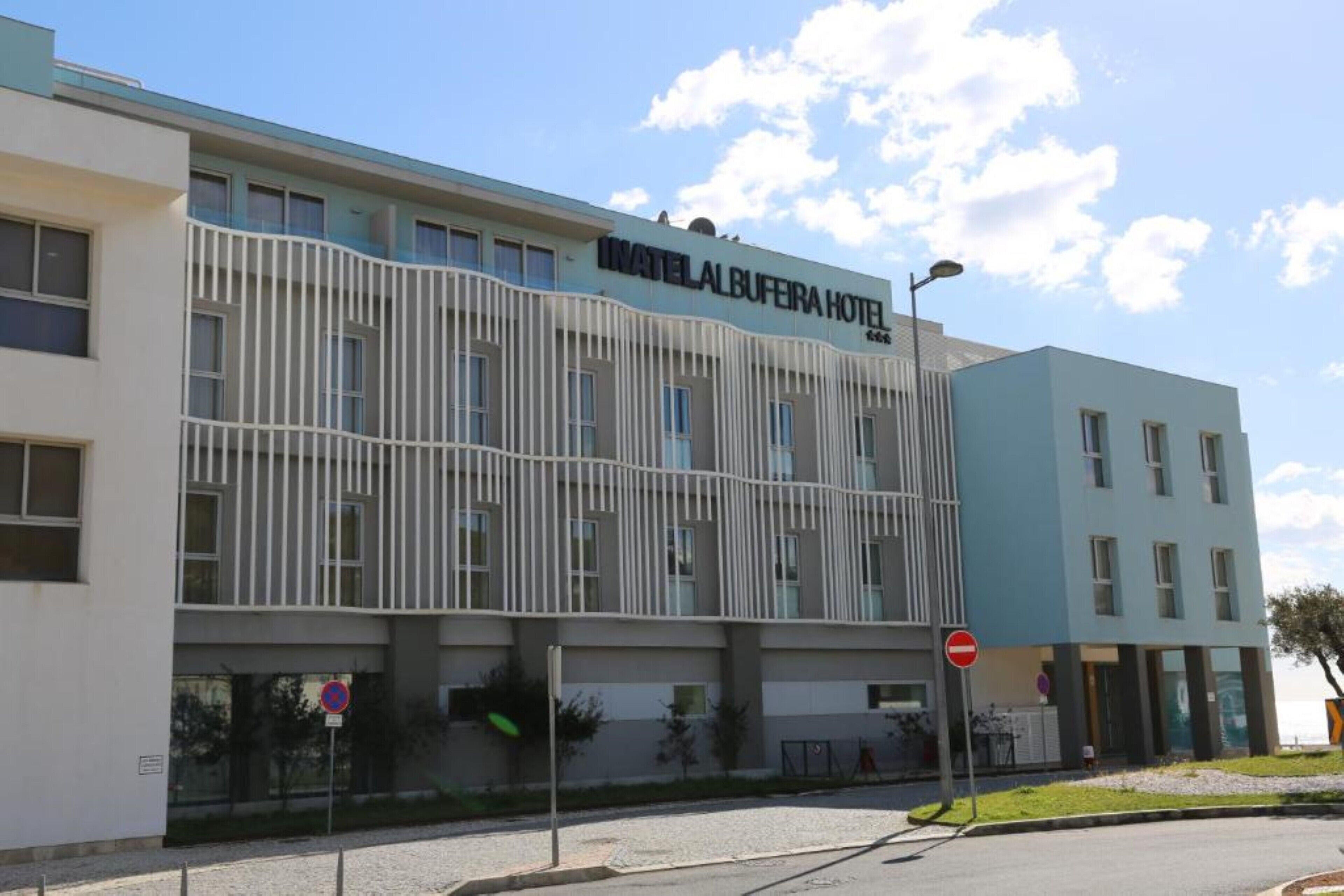 Ein Hotel mit moderner Fassade, einem gut sichtbaren Schild und einem Verbotsschild.
