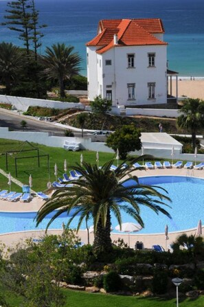 Una piscina al aire libre, sombrillas, tumbonas