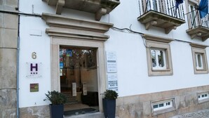 A hotel entrance with a number '6' sign, a glass door, and two potted plants. - INATEL Castelo de Vide (Castelo de Vide)