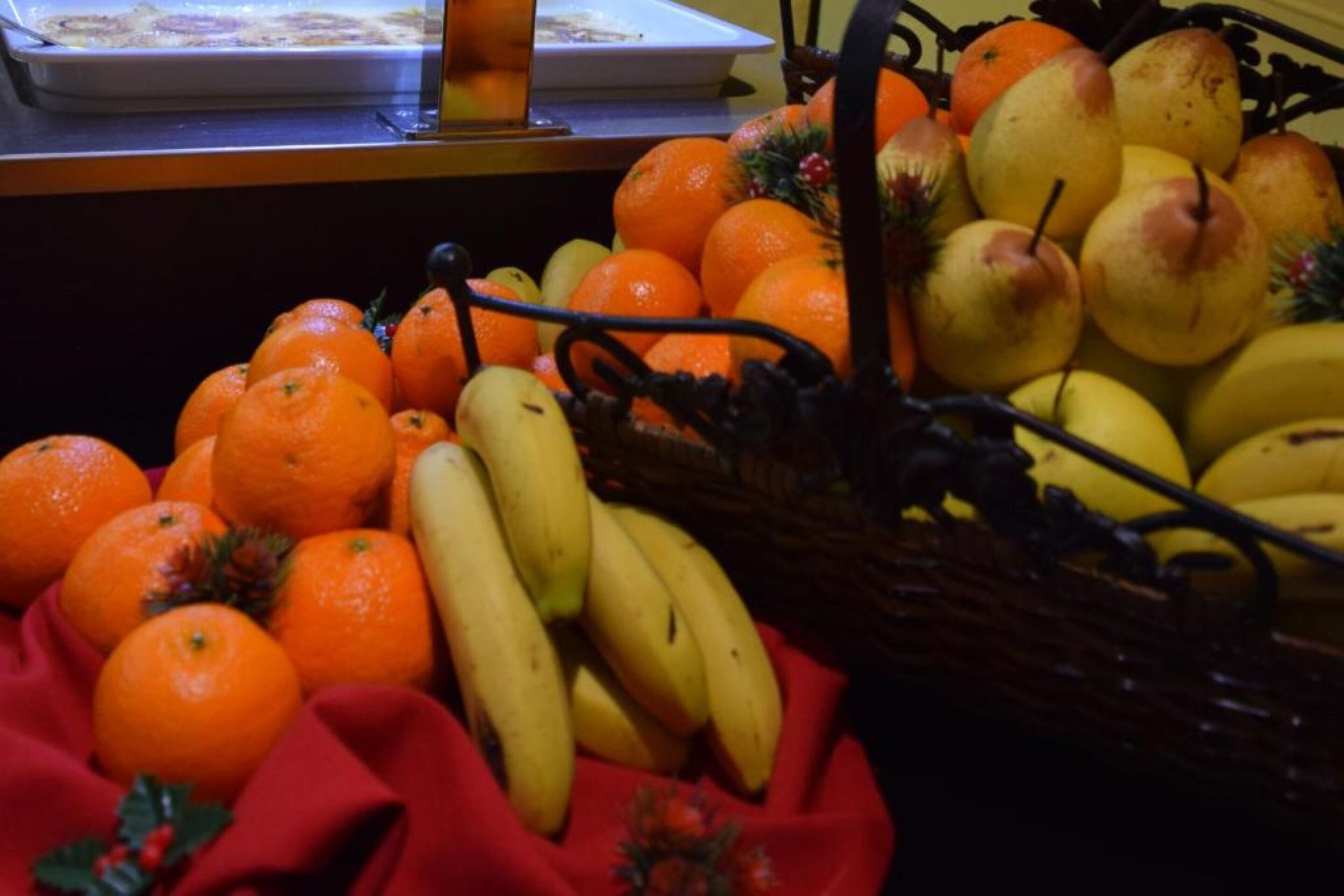 A fruit display with oranges, bananas, and pears.