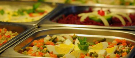 A buffet with various dishes including salads, vegetables, and eggs.