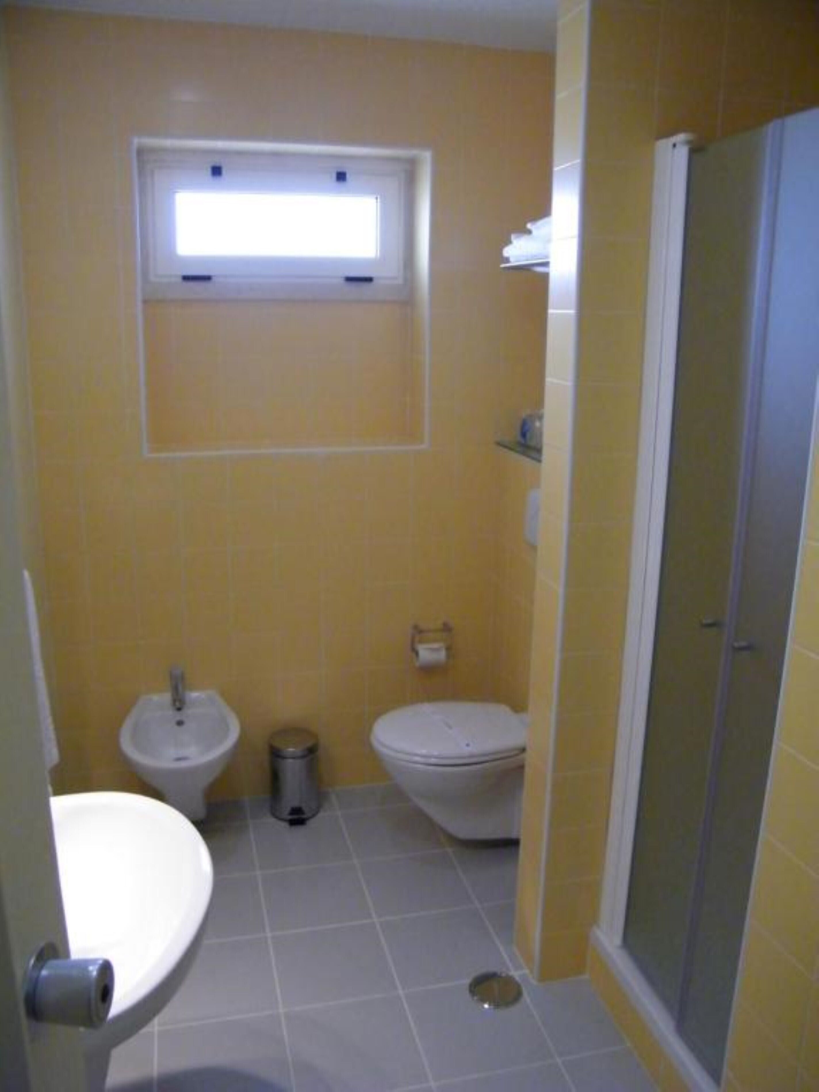 Un bagno piccolo con il water, un bidet e una cabina doccia.