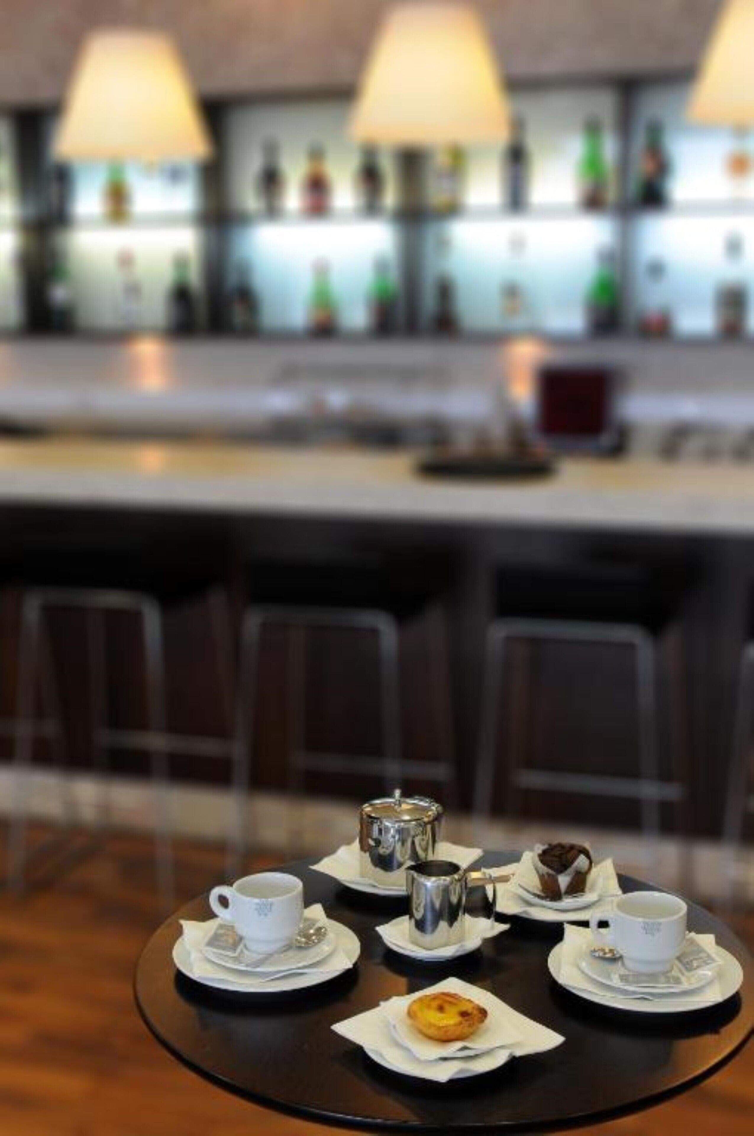 A dining table with a coffee setup and pastries in a modern restaurant setting.