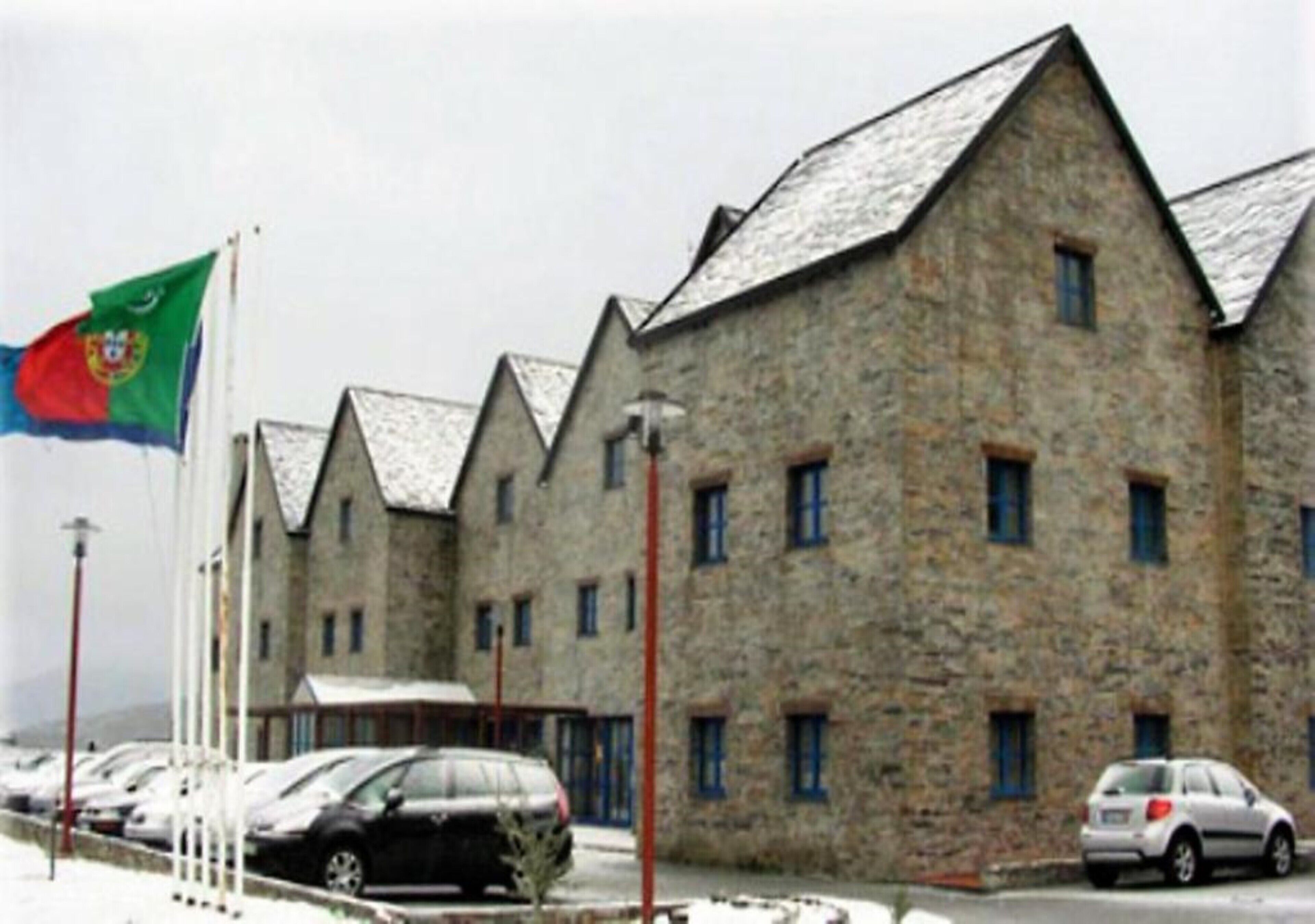 Un edificio de piedra con múltiples ventanas y una bandera.