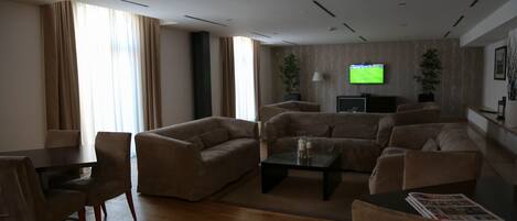 Una sala de estar moderna con un conjunto de sofá, una mesa de centro y un televisor montado en la pared.