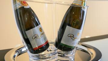 Twee champagnefluiten met een flesetiket, geplaatst op een reflecterende schaal.
