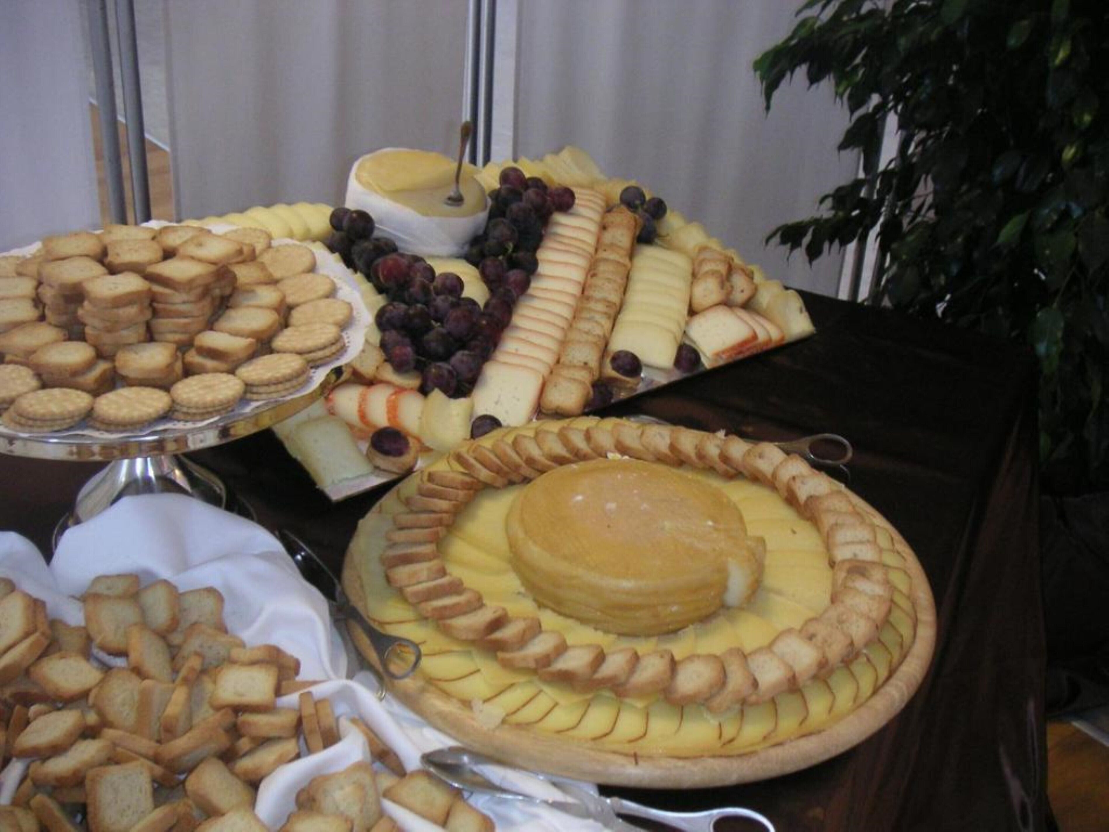 A buffet table with various food items including cheese, crackers, and fruits.