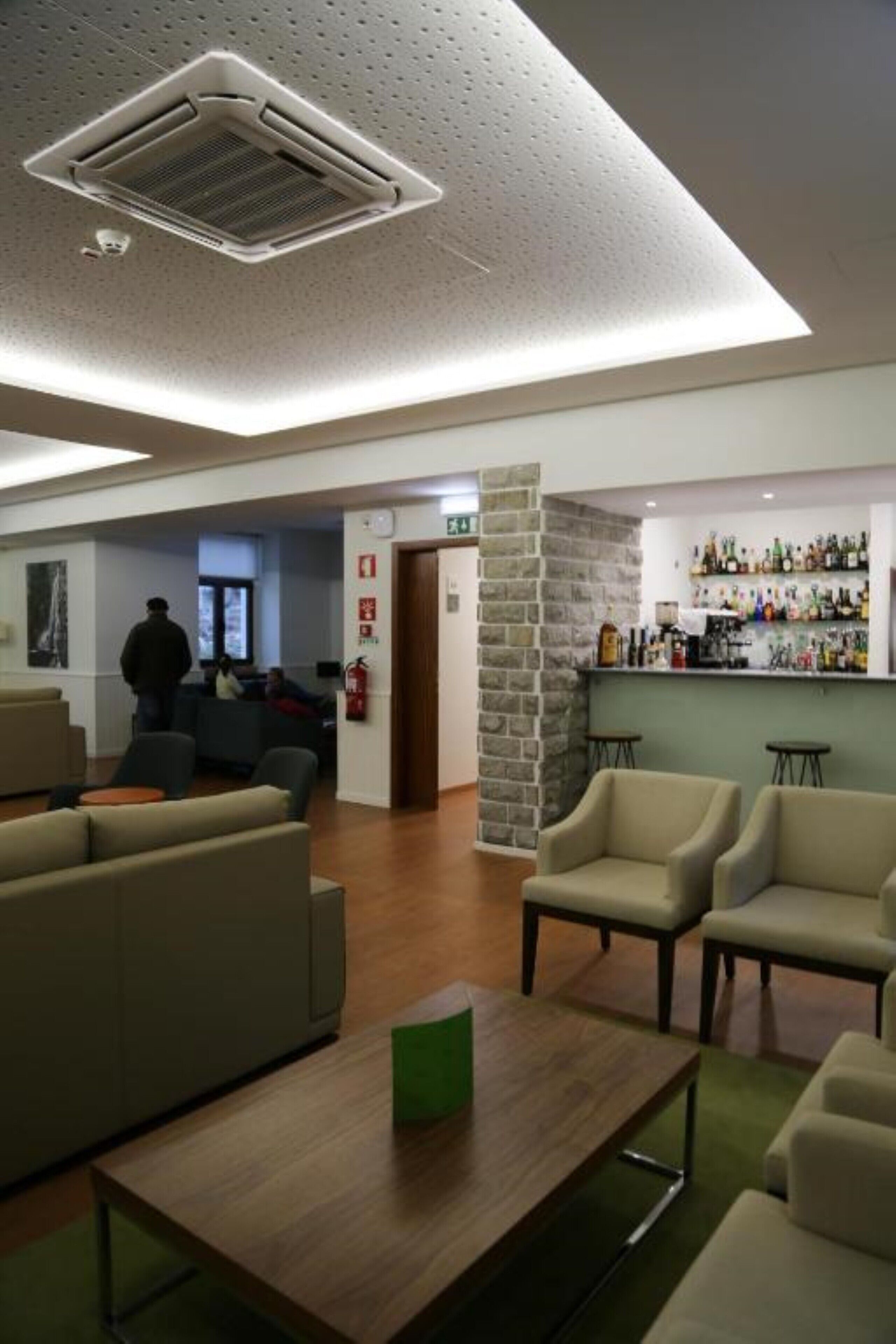 Un hall d’entrée avec un bar, des sièges et un système d’alarme incendie.