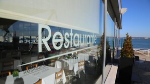A restaurant with outdoor seating overlooking the sea. - INATEL Oeiras (Oeiras)