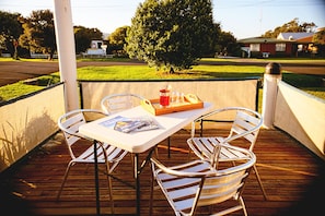 Relax in a serene outdoor space with a comfortable seating area and a table set for a refreshing meal.