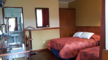 Una habitación con una cama y un armario de madera, un lavabo y un espejo.