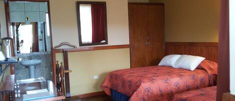 Una habitación con una cama y un armario de madera, un lavabo y un espejo.