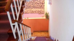 A staircase with white railings and a stone wall in the background. - Kuntur Inn (Puno)