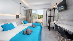 A hotel room with two beds, a desk, and a TV. - Casa Stavris (Rhodes)