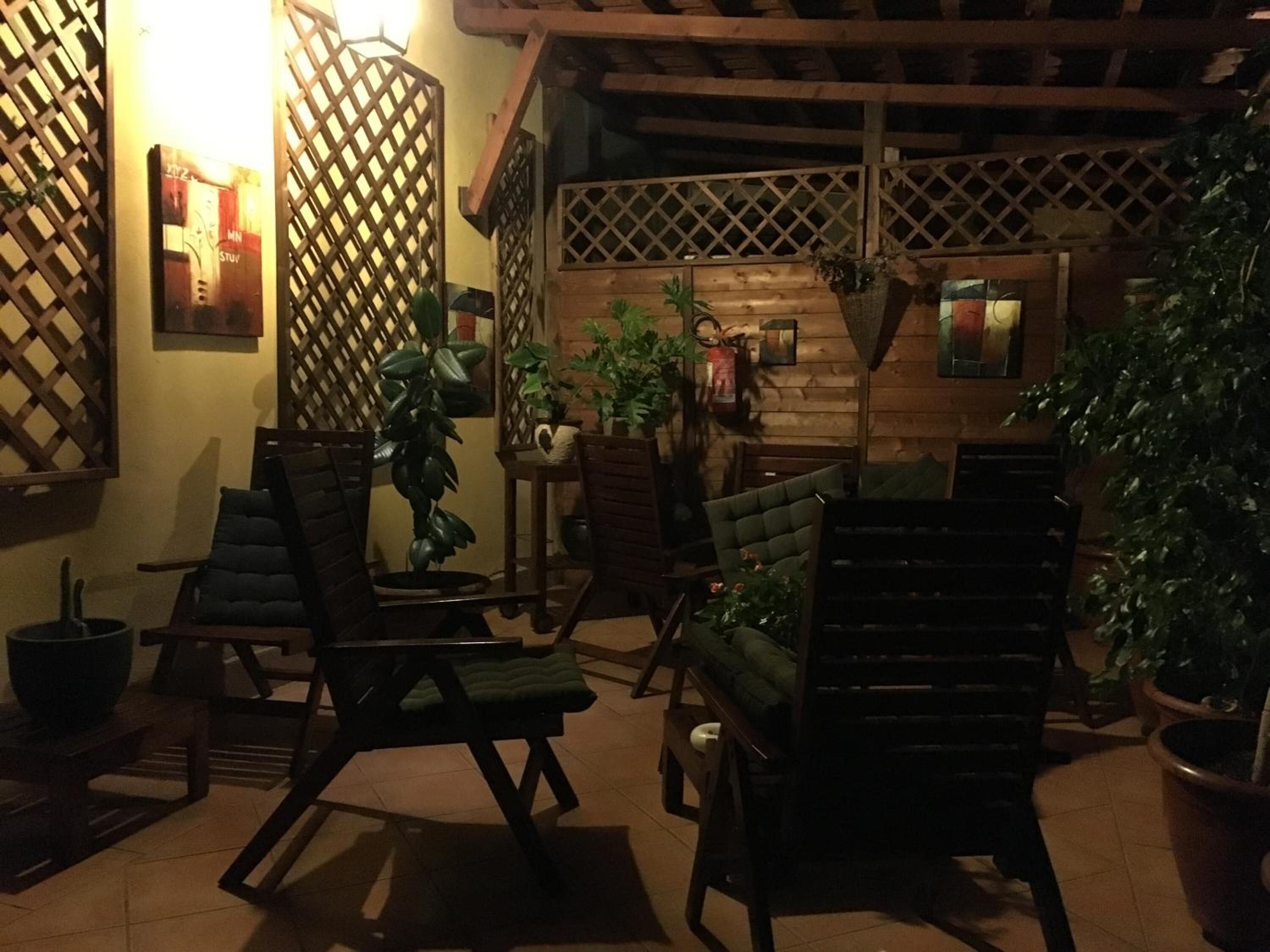 Een gezellig terras met houten meubels en plantenpotten.