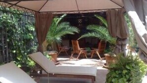 An outdoor seating area with lounge chairs and a covered patio. - Hotel Amadeus (Caserta)