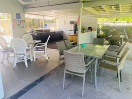 A cafe with outdoor seating, a kitchen area, and a sign indicating a camp kitchen.