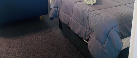 A hotel room with two beds, a TV, a desk, and a chair.