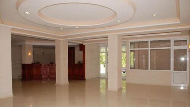 A spacious interior with a high ceiling, large windows, and a polished floor. - Hotel Feni (Kavadarci)