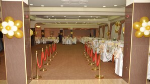 A banquet hall with tables set for a formal event, red velvet ropes, and golden balloons. - Hotel Feni (Kavadarci)