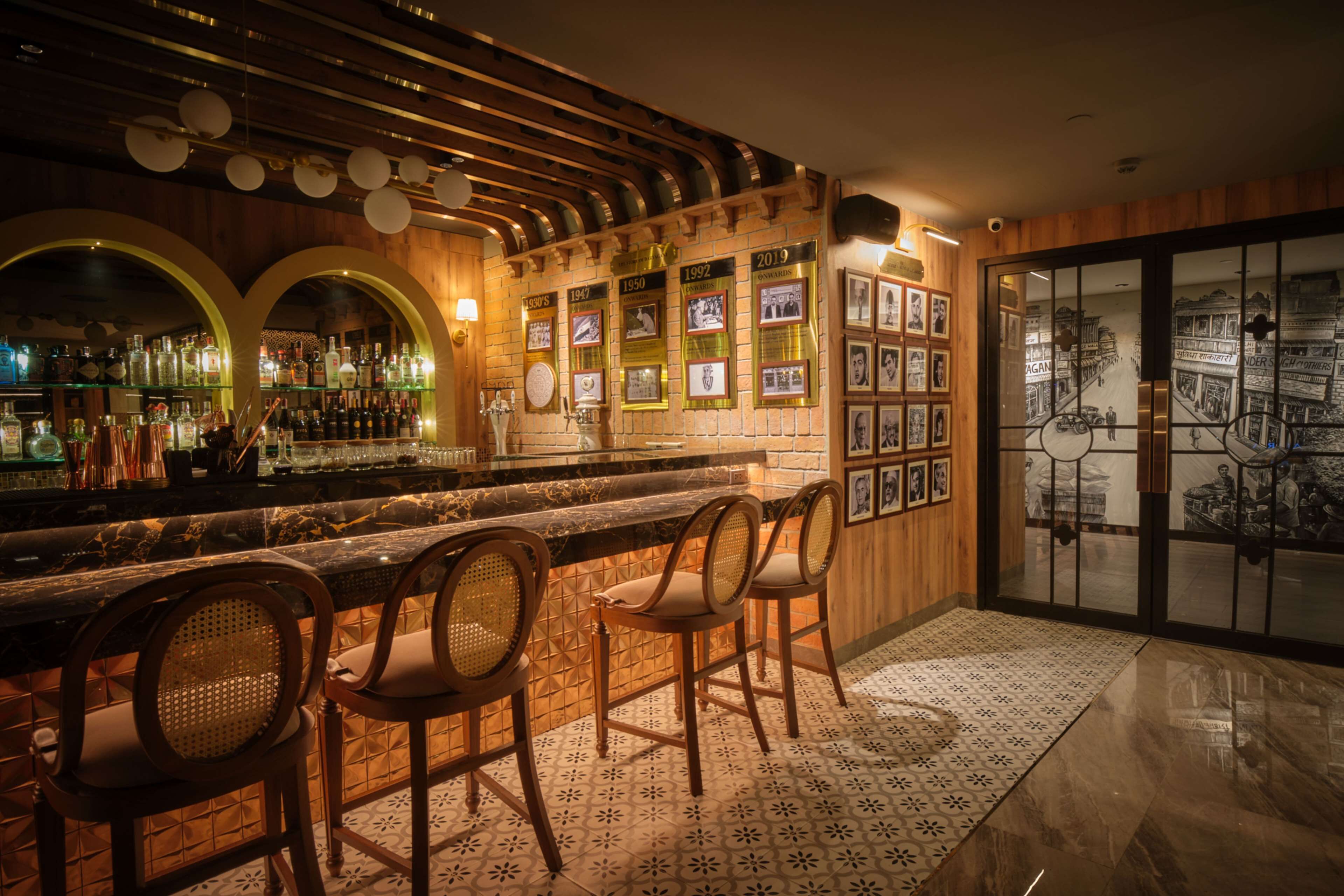 A bar area with wooden decor, a marble countertop, and framed pictures on the wall.