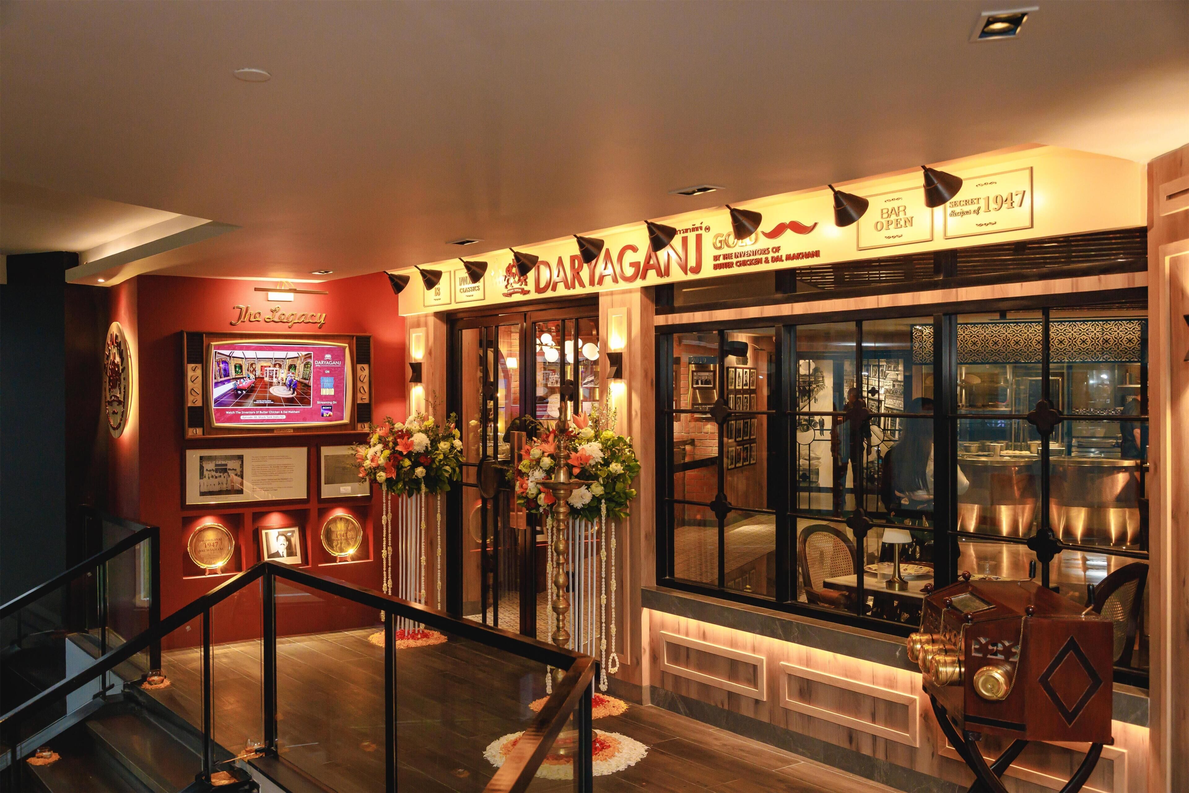 A restaurant interior with a bar, framed pictures, and a staircase.