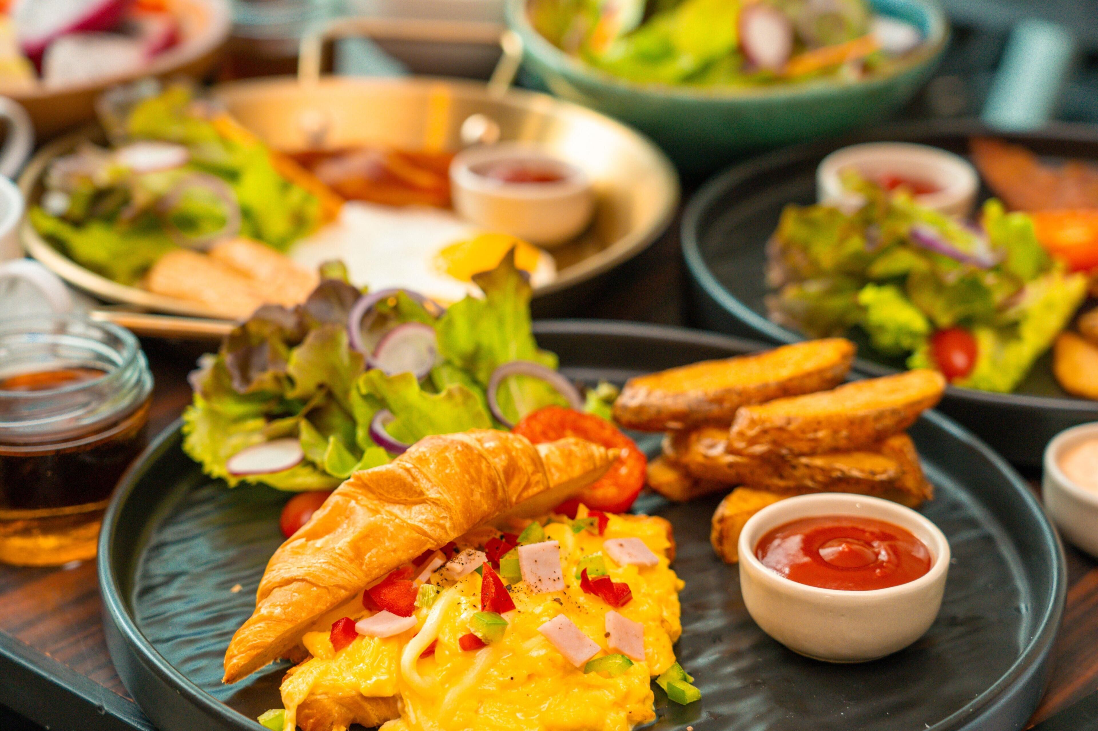 A variety of breakfast items including eggs, croissants, and toast on a plate.