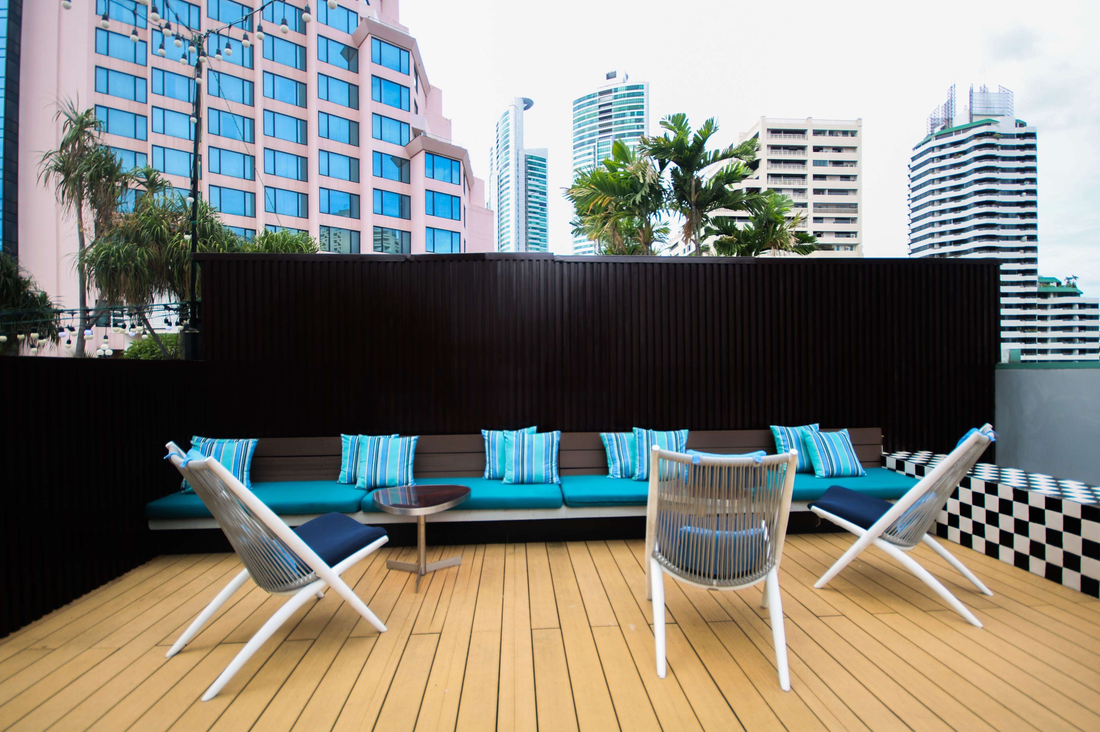 Una piscina al aire libre, sombrillas, sillones reclinables de piscina