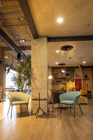 A modern interior with wooden flooring, a central column, and seating arrangements.